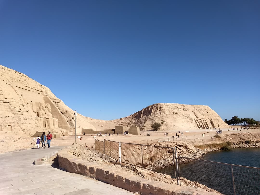 Les temples d’Abou Simbel au coucher du soleil, jetant une lueur dorée sur les falaises de grès.