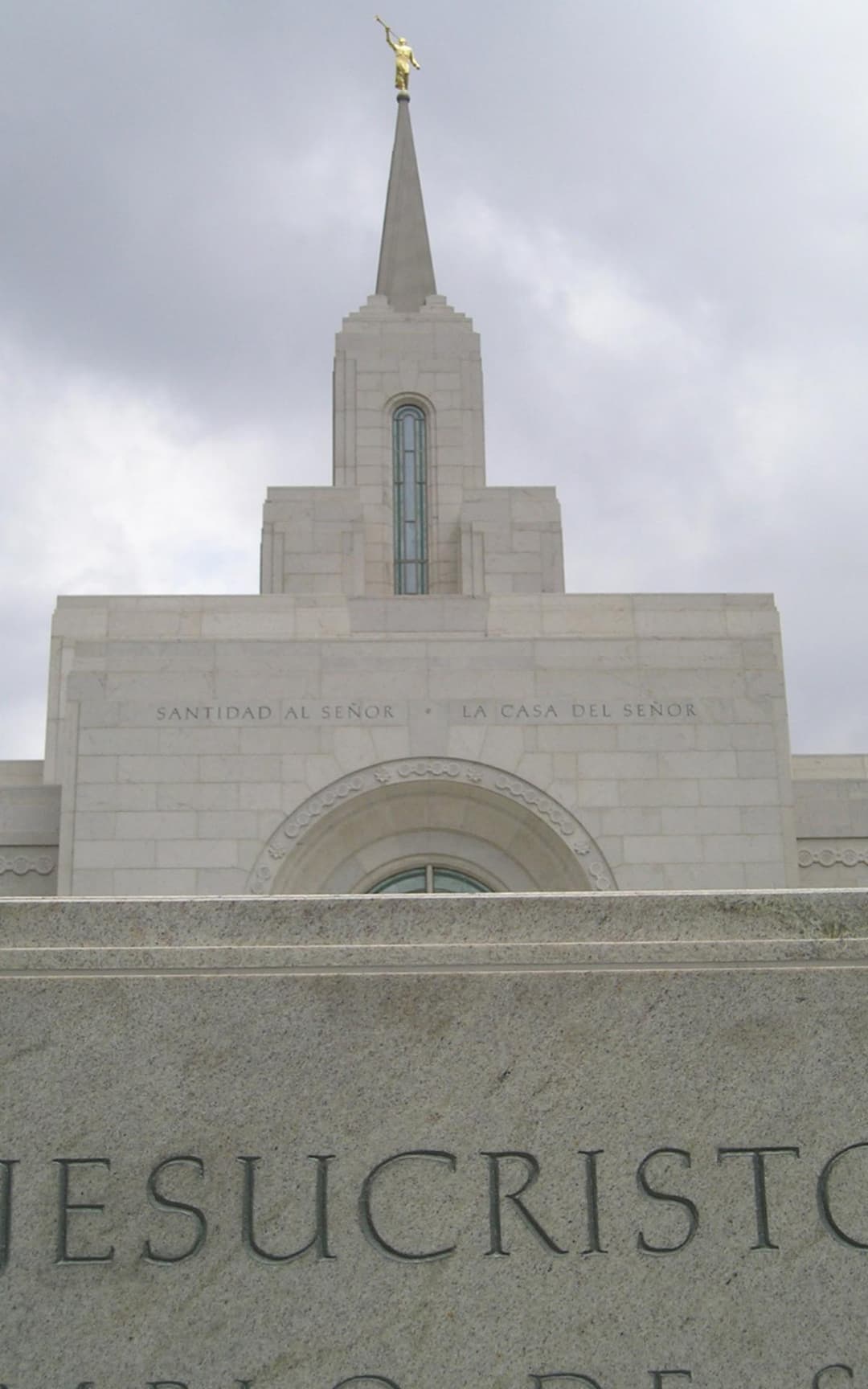 Low-angle view of the front facade inscription and central spire.