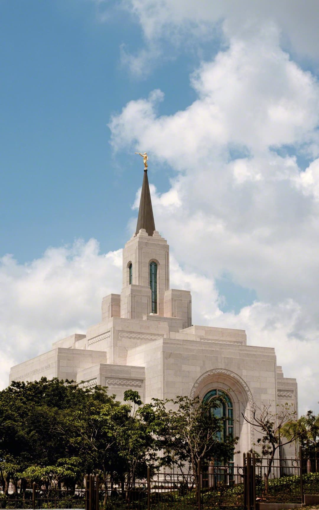 Exterior view of the San Salvador Temple spire rising above trees.