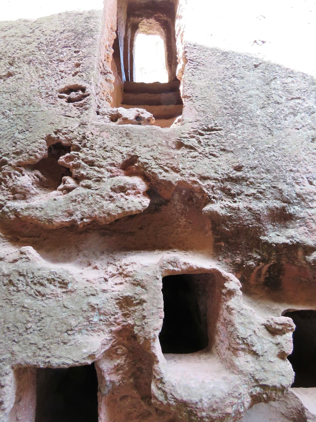 Rock-hewn chambers and carved upper portal in the rock wall, Lalibela