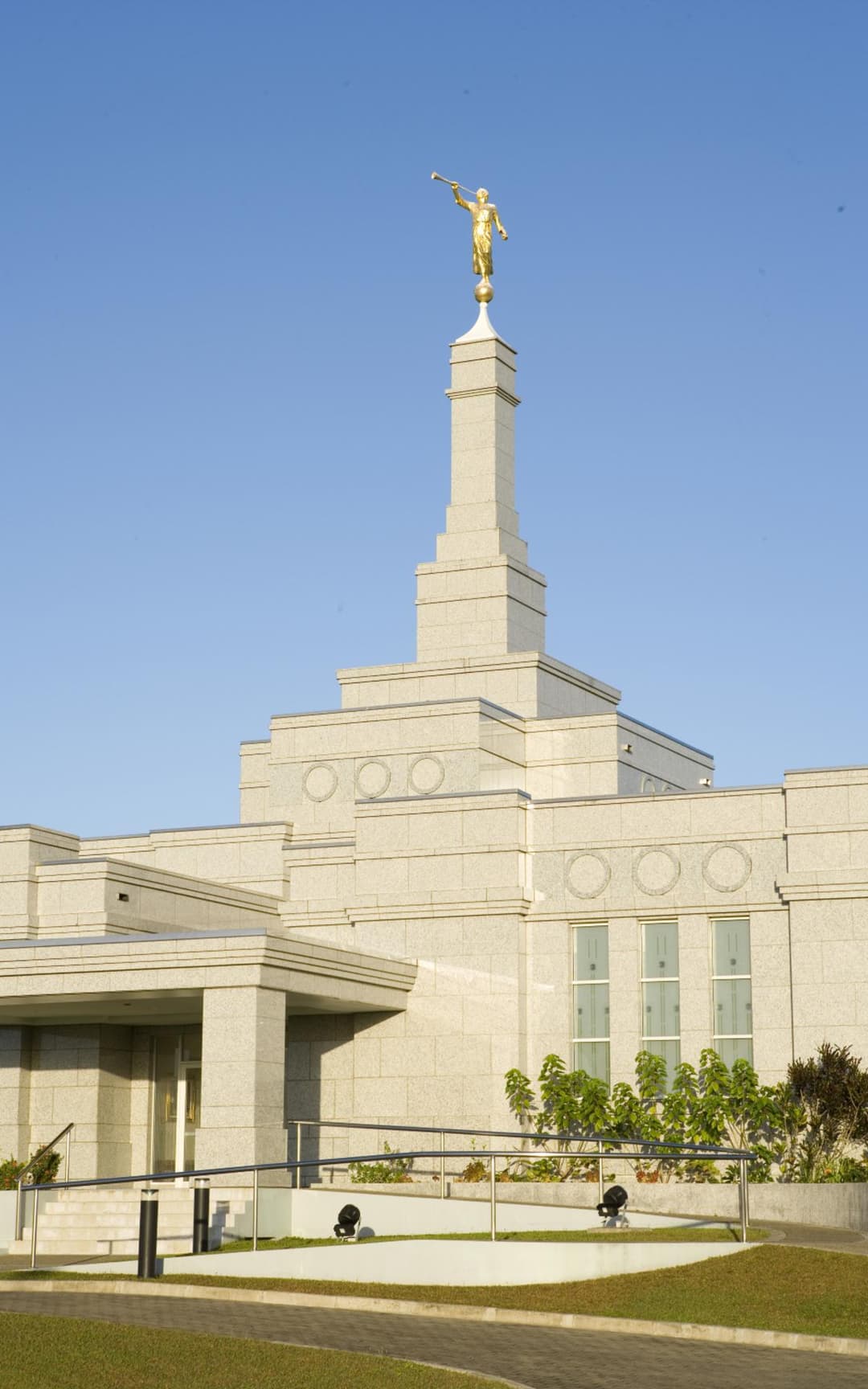 Low-angle exterior view of the Suva Fiji Temple spire and front entrance.
