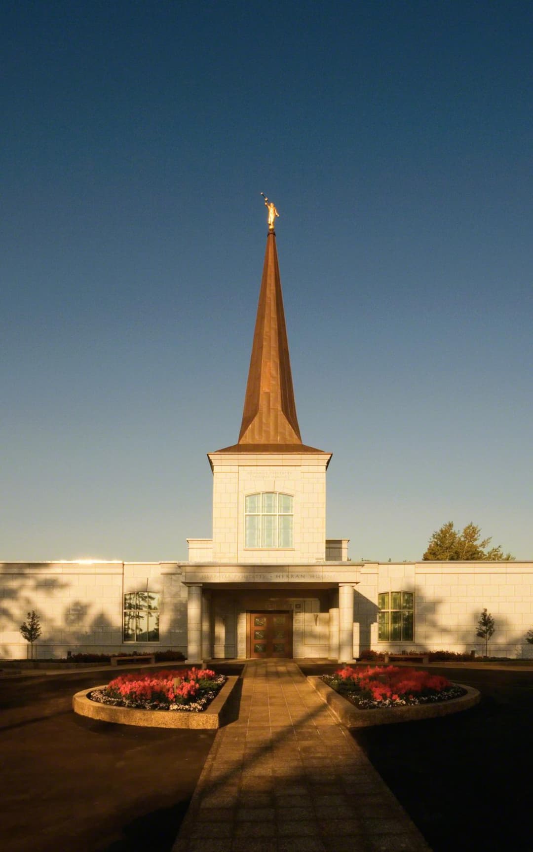 Helsinki Finland Temple front entrance, spire with Angel Moroni, and gardens.