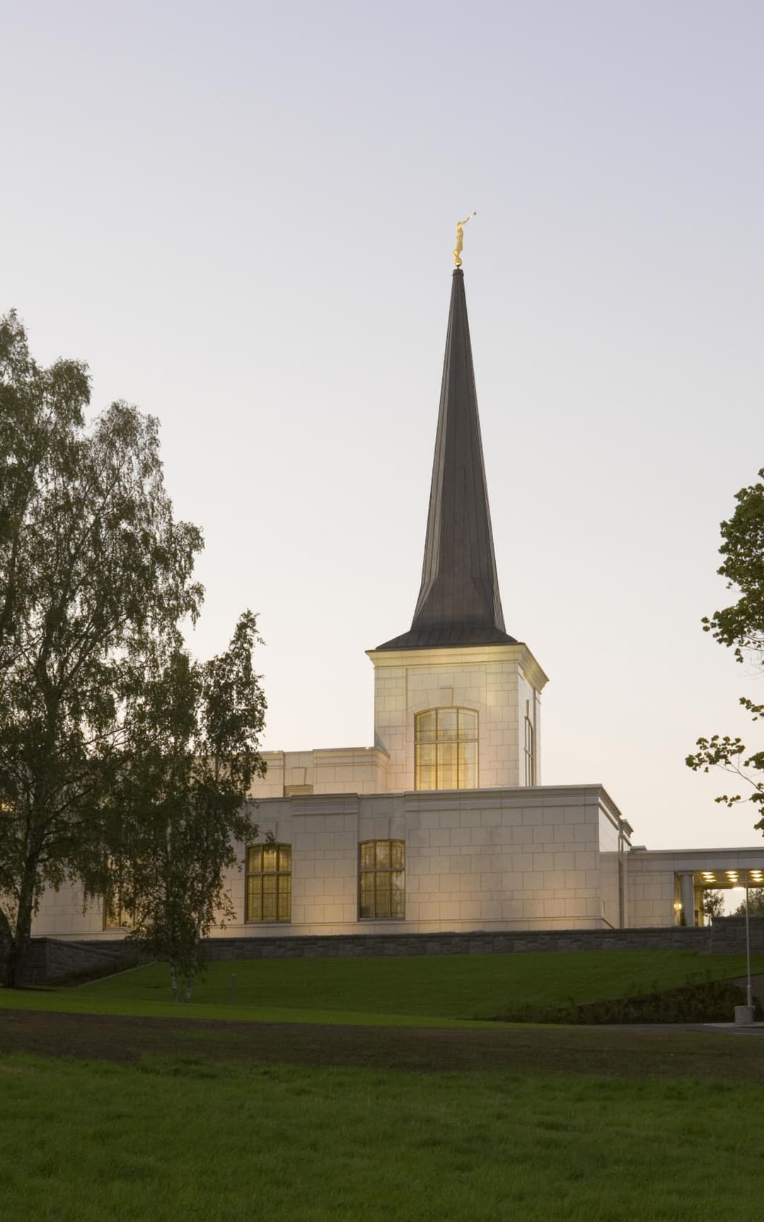 Helsinki Finland Temple at twilight, showing spire and grounds.