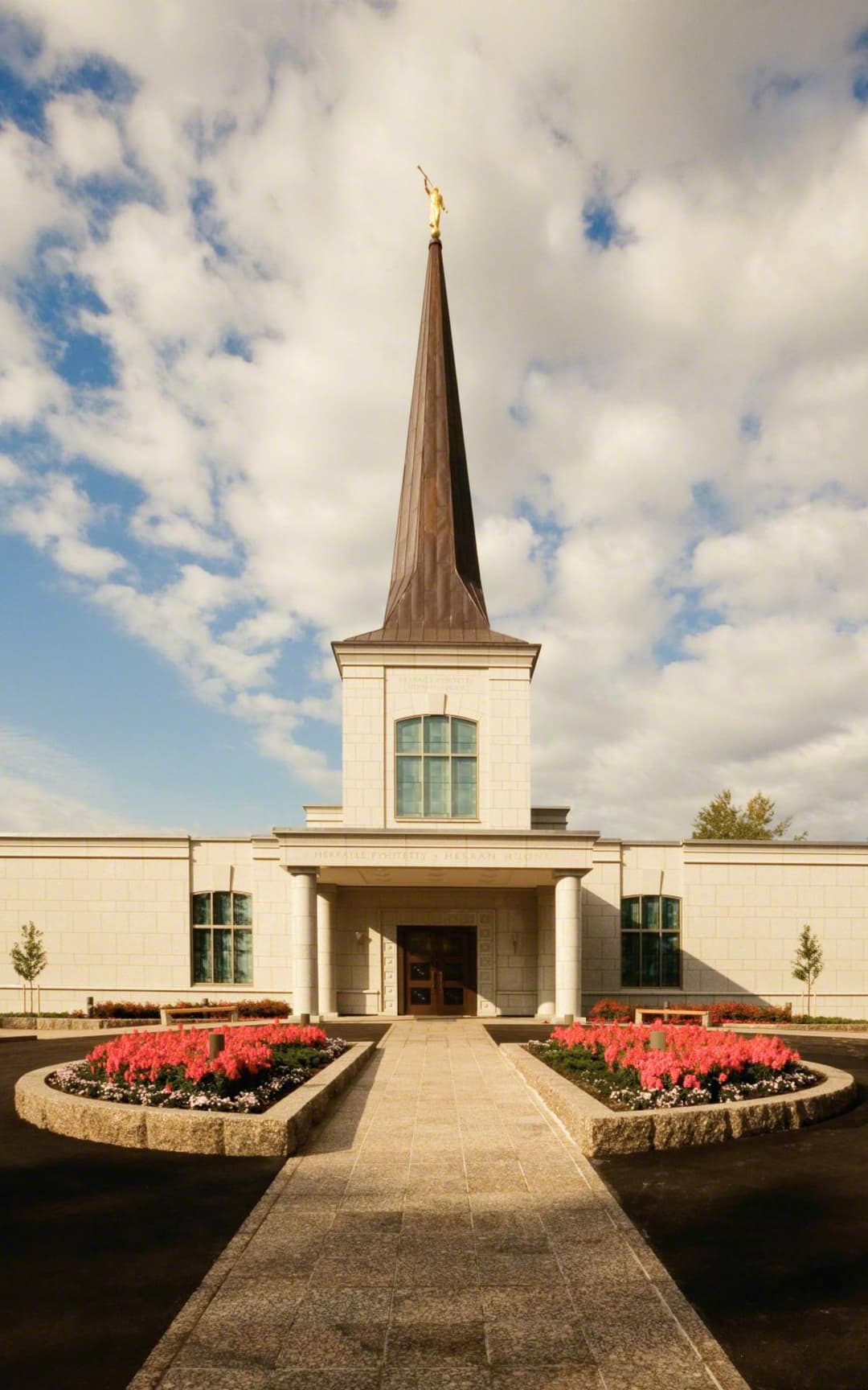 Helsinki Finland Temple: front exterior with spire, Angel Moroni, and gardens.