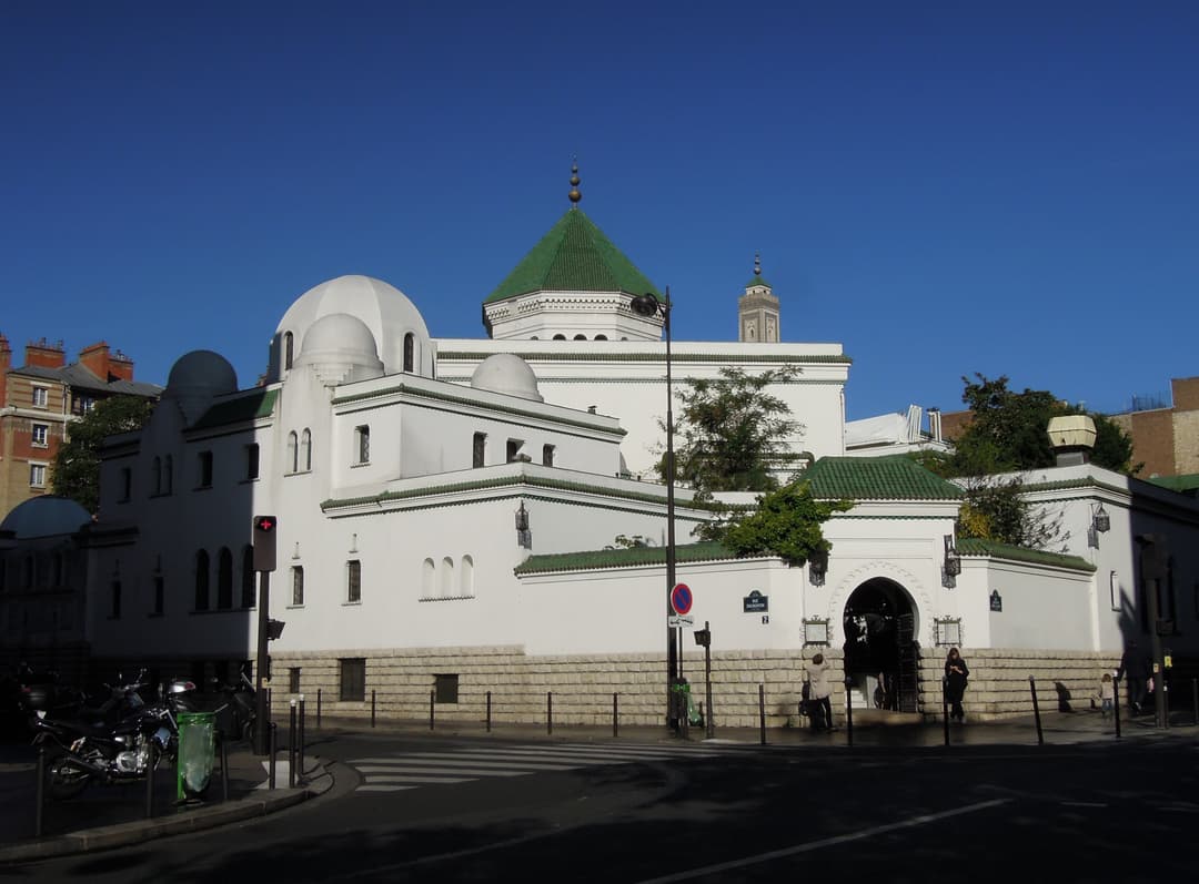 Exterior street view of the Grande Mosquée de Paris facade and arched entrance.