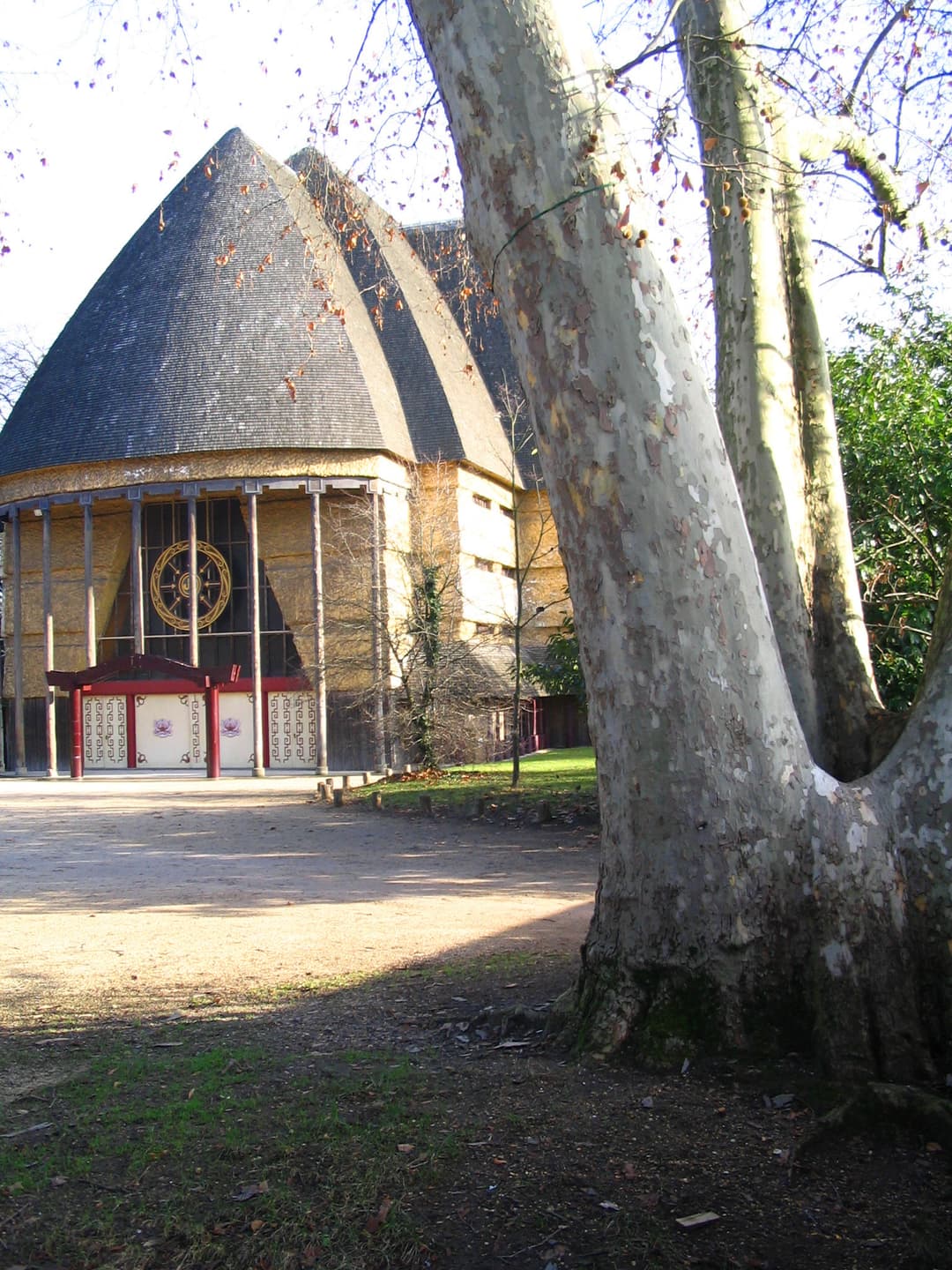 Exterior view of the Grande Pagode framed by a large plane tree