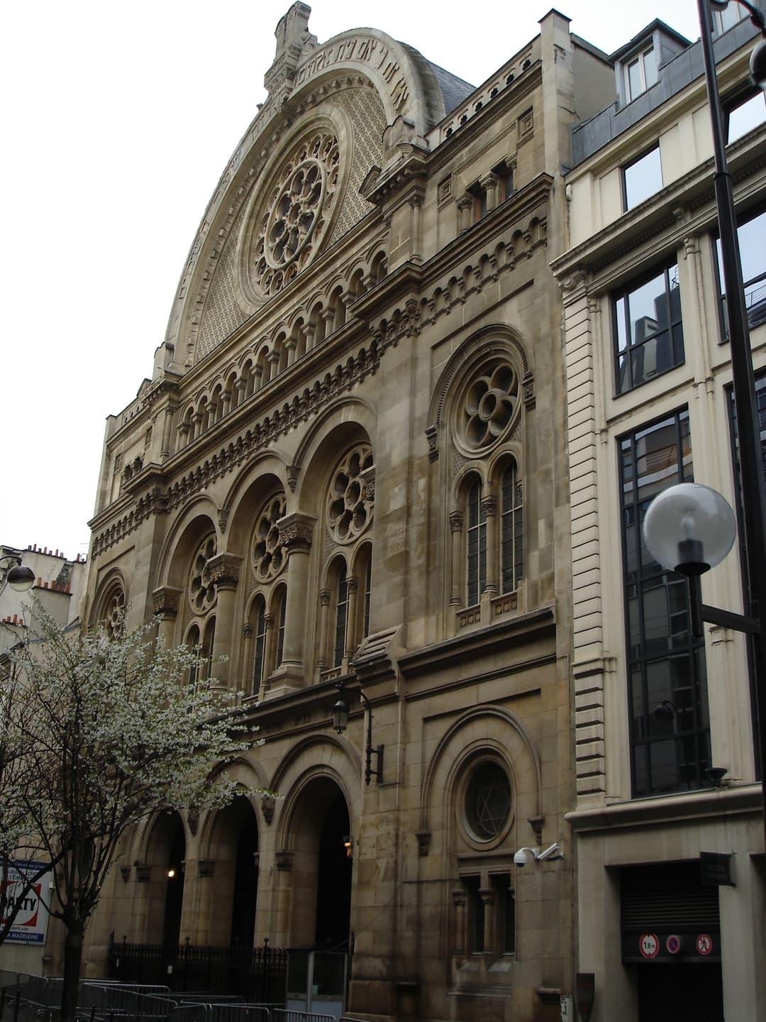 Angled street-level view of the Grande Synagogue de Paris facade.