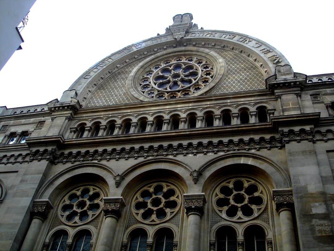 Low-angle view of the upper facade and rose window of the synagogue.
