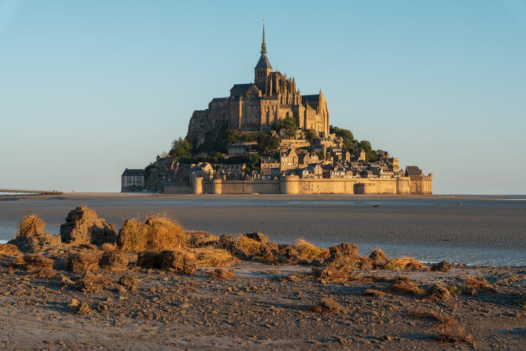 Mont-Saint-Michel across the tidal flats at golden hour