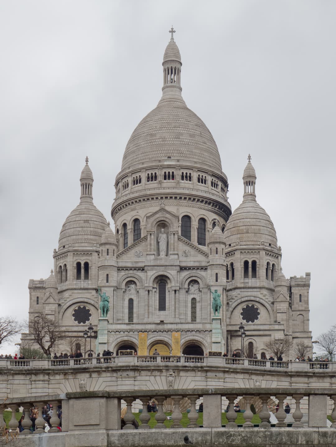 Front facade and central dome of Sacré-Cœur Basilica viewed from below.
