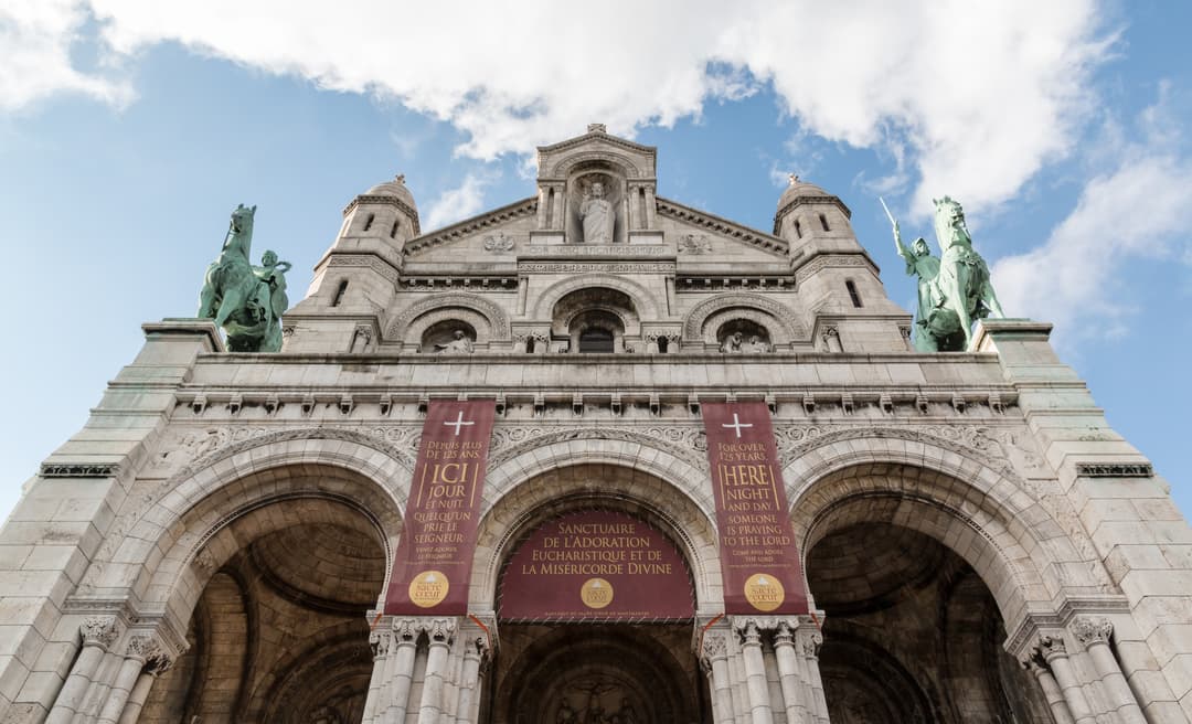 Low-angle view of the main entrance facade of Sacré-Cœur Basilica.