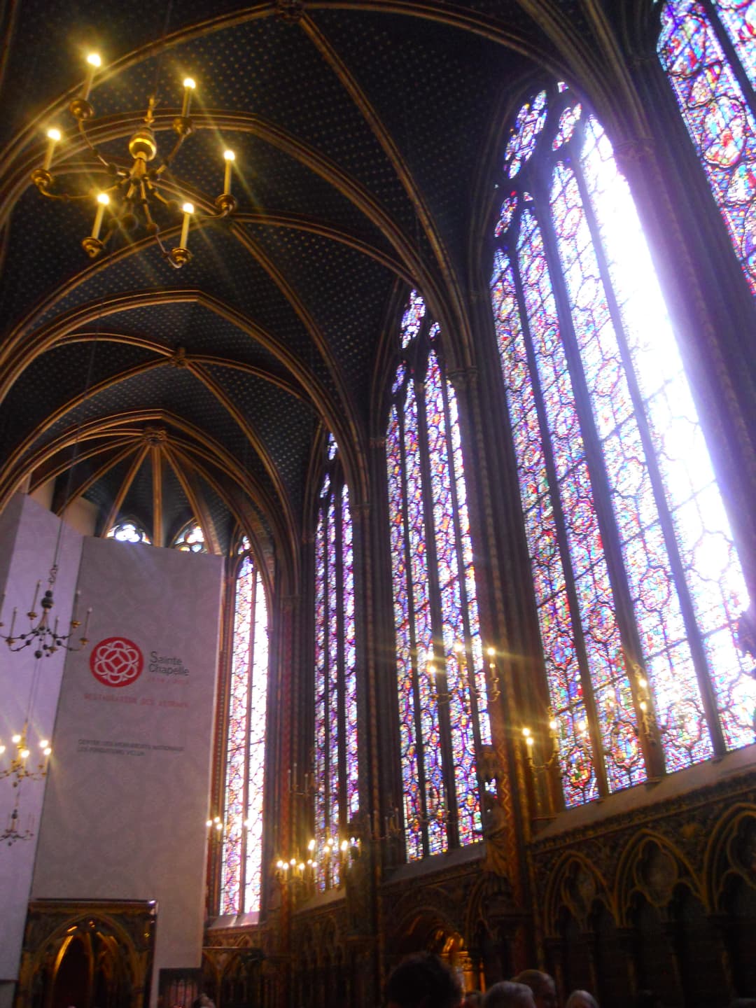 Interior of Sainte-Chapelle with stained glass windows and vaulted ceiling.