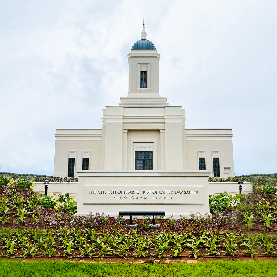 Front view of the Yigo Guam Temple exterior with entrance sign and tower.