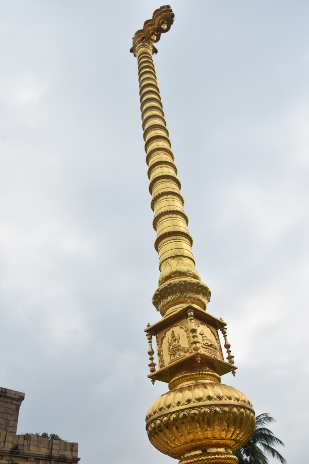 Low-angle view of the golden Dhwaja Stambha (temple flagstaff)