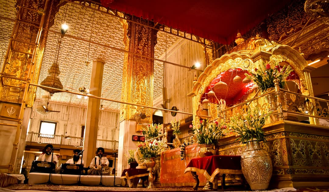 Gurdwara Bangla Sahib prayer hall, showing musicians and golden shrine.