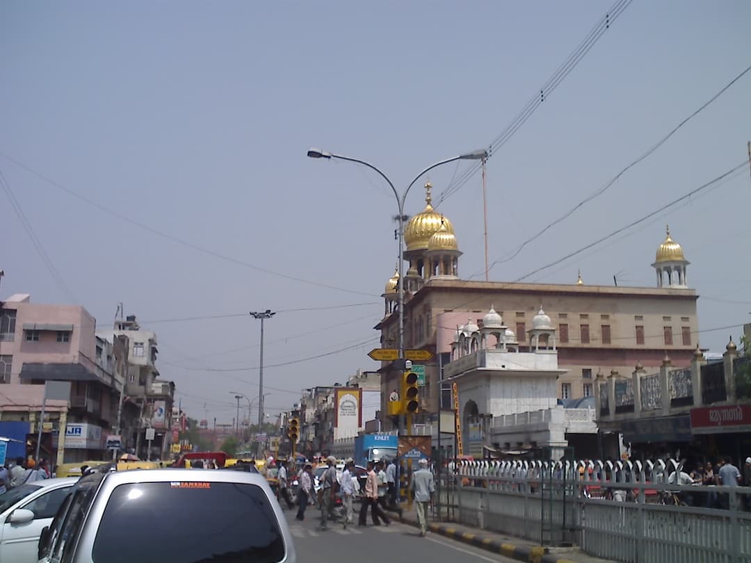 Gurudwara Sis Ganj Sahib, street view with gold domes.