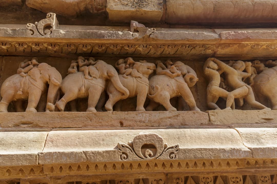 Detail of carved elephant procession frieze on the exterior temple plinth