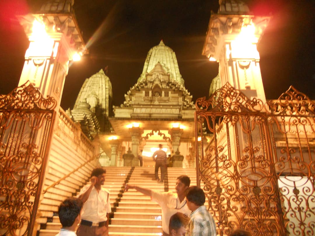 Illuminated front entrance and spires of Birla Mandir Kolkata at night.