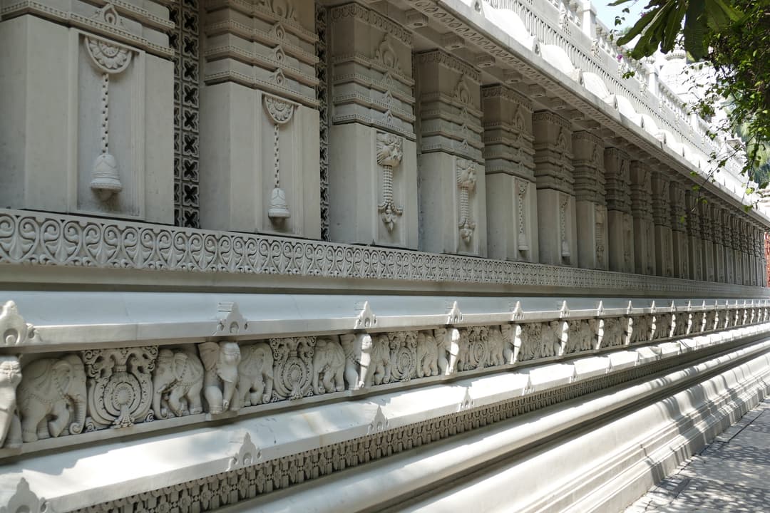 Low-angle view of the carved elephant frieze along Birla Mandir's exterior wall.