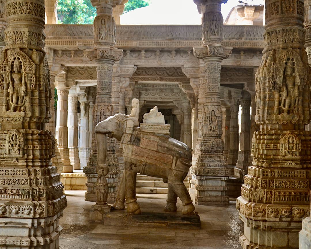 Carved marble elephant statue framed by ornate pillars inside the temple