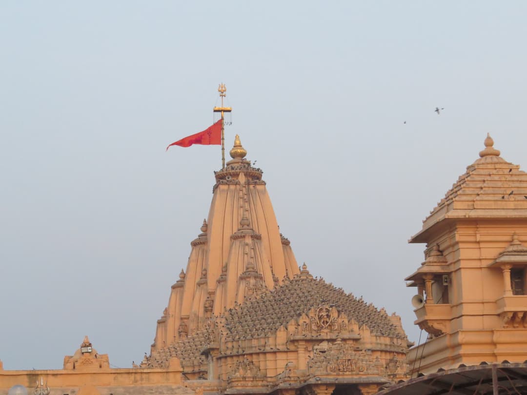 The main shikhara and fluttering flag of Somnath Temple in evening light
