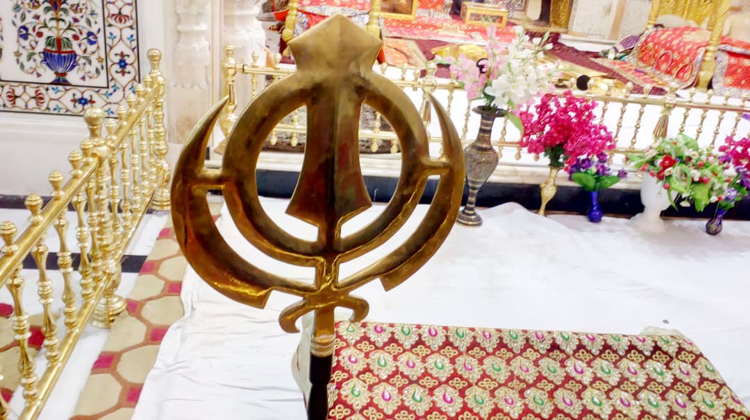 Il Nishan Sahib, una bandiera Sikh, che sventola alta al Gurdwara