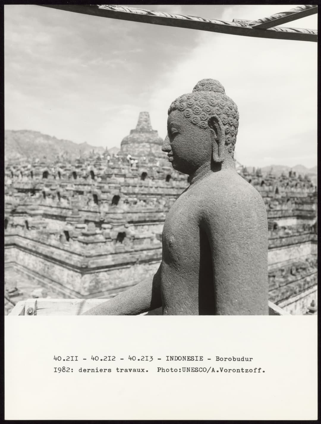 Borobudur : statue de Bouddha de profil, avec des stupas en arrière-plan.