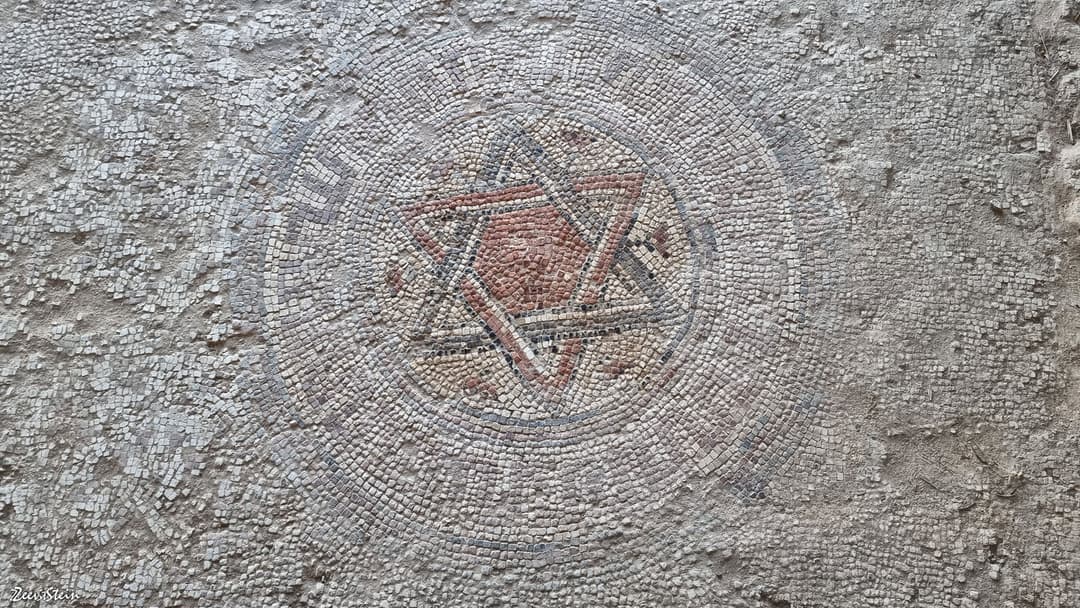 Well-preserved ancient mosaic floor displaying geometric patterns.