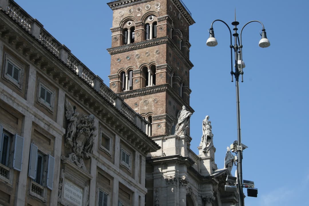 Low-angle exterior view of Santa Maria Maggiore's bell tower in daylight.