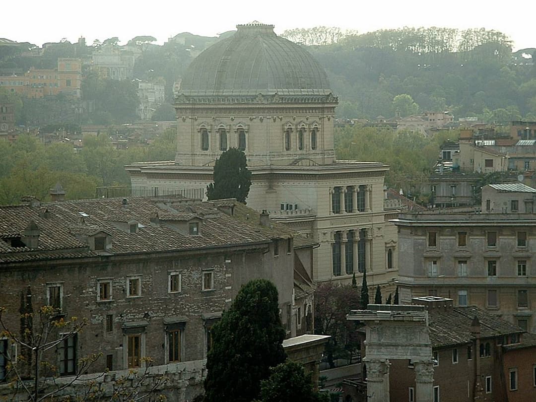 Elevated view of the Great Synagogue of Rome's dome over city rooftops.