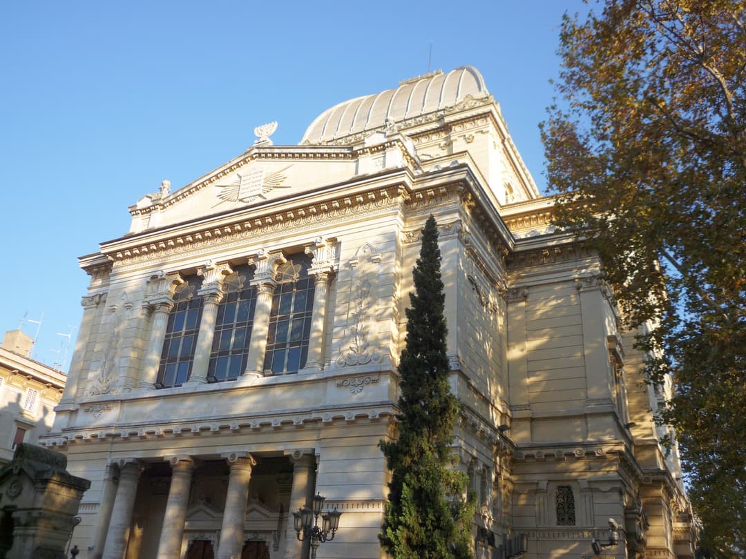 Low-angle exterior view of the Great Synagogue of Rome in sunlight.