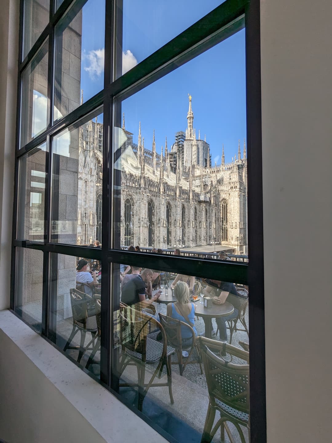 Milan Cathedral spires framed through a cafe terrace window