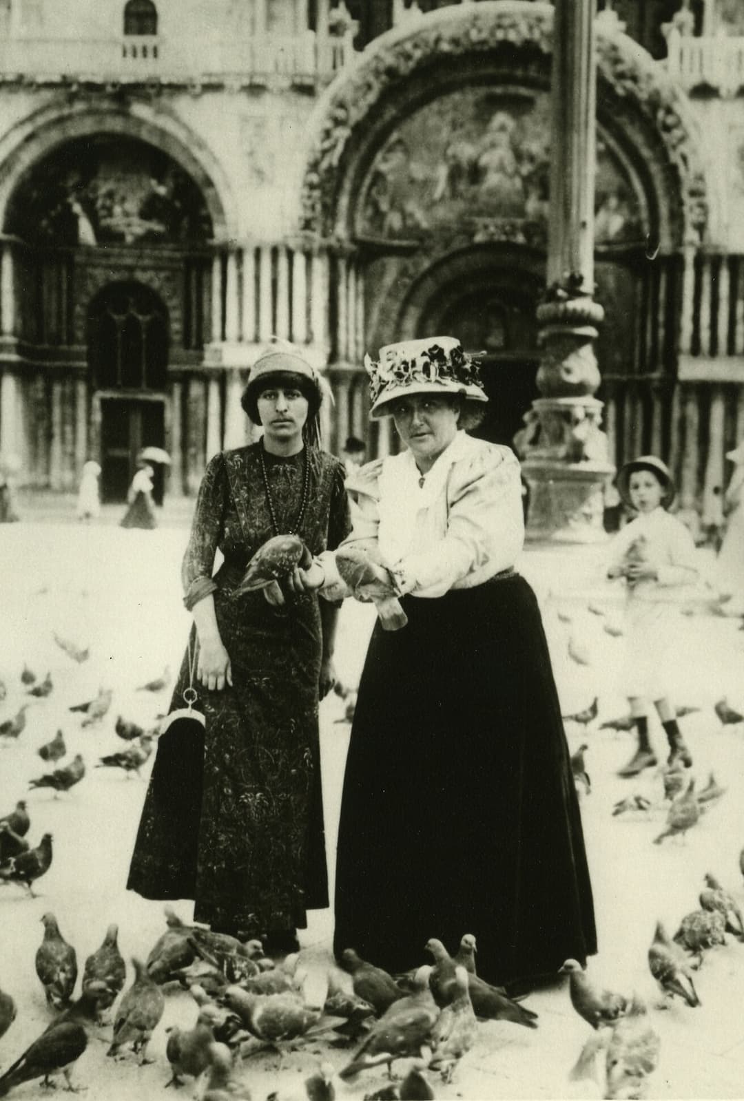 Vintage photo of tourists feeding pigeons before St. Mark's Basilica