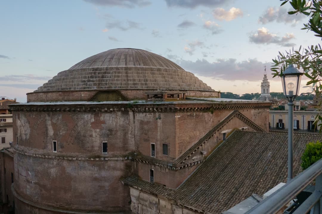 Elevated view of the Pantheon's exterior rotunda and dome at twilight.