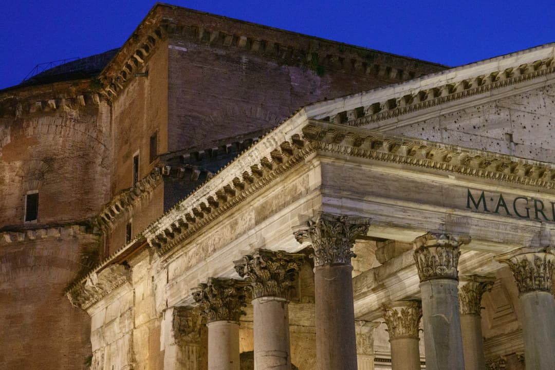 Low-angle view of the Pantheon's portico and brick facade at twilight.