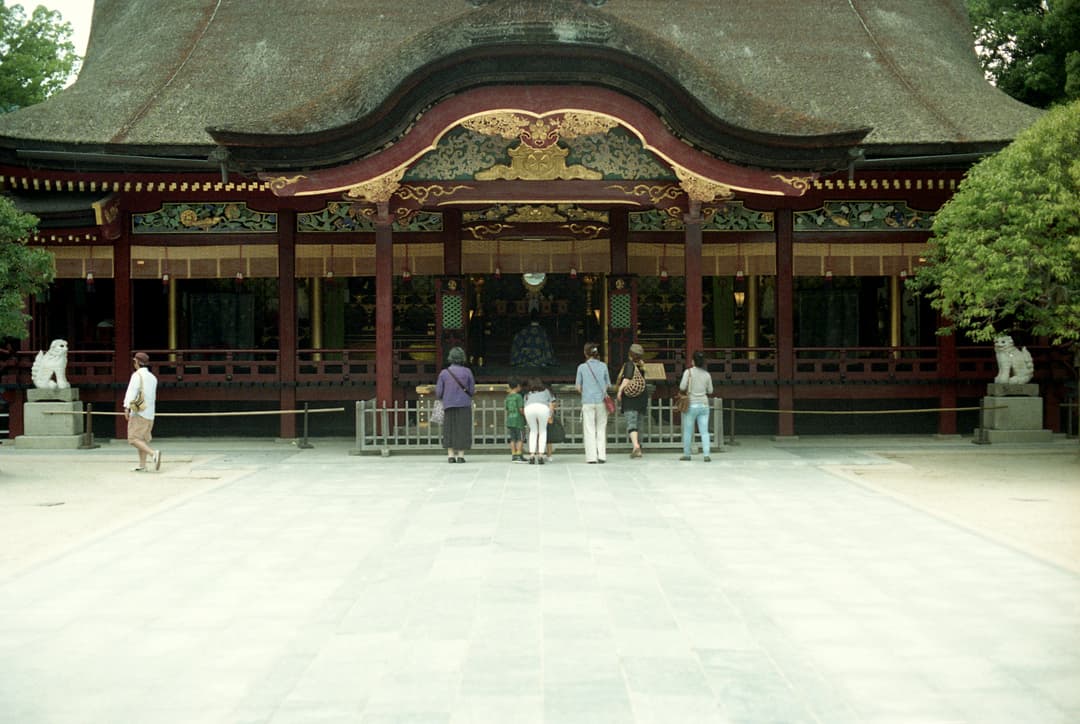 Front view of the ornate Honden (Main Hall) with worshippers.
