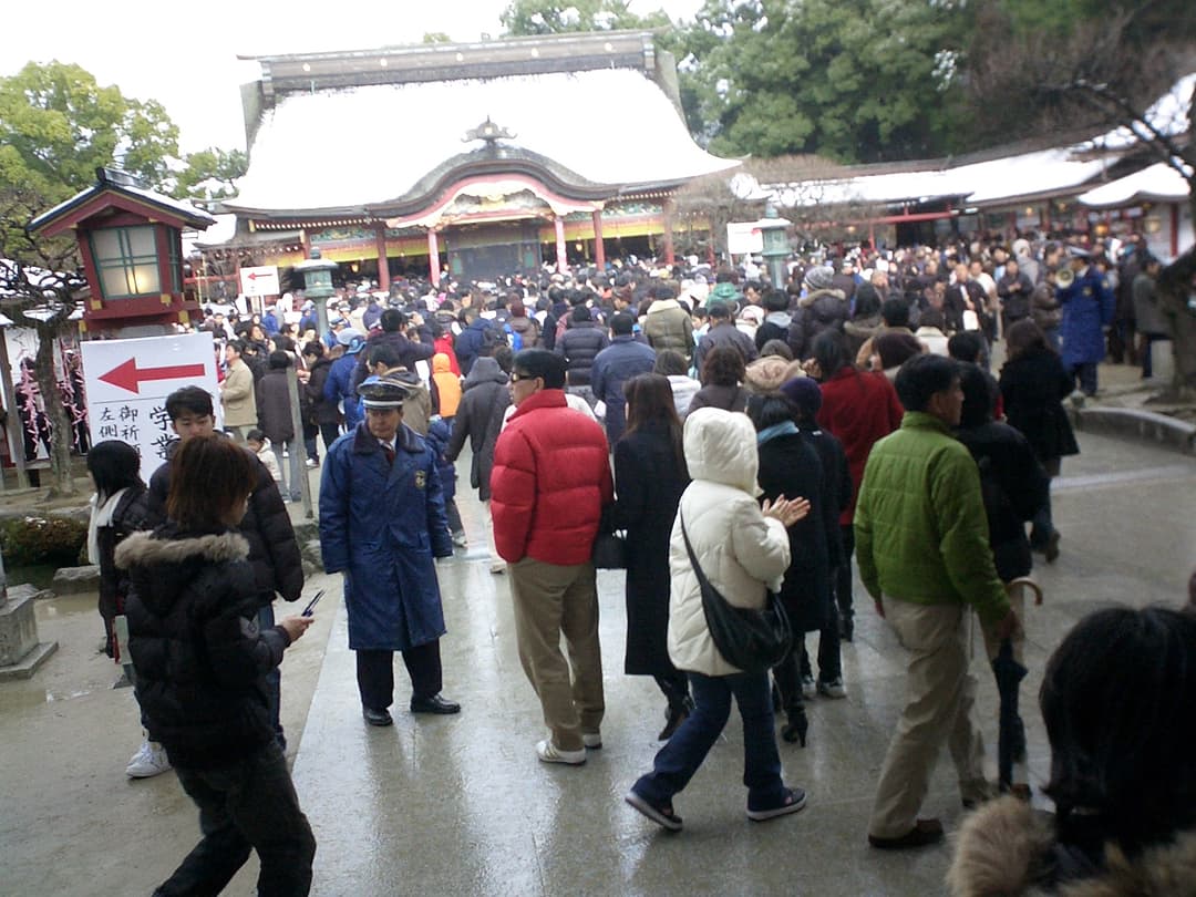 Crowds gather before the snow-covered main hall at Dazaifu Tenman-gū.