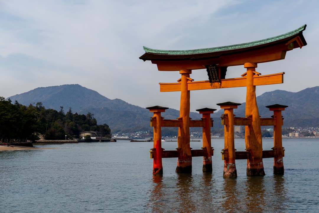 इत्सुकुशिमा मंदिर की सिंदूर-लाquered संरचनाओं का एक क्लोज-अप दृश्य।