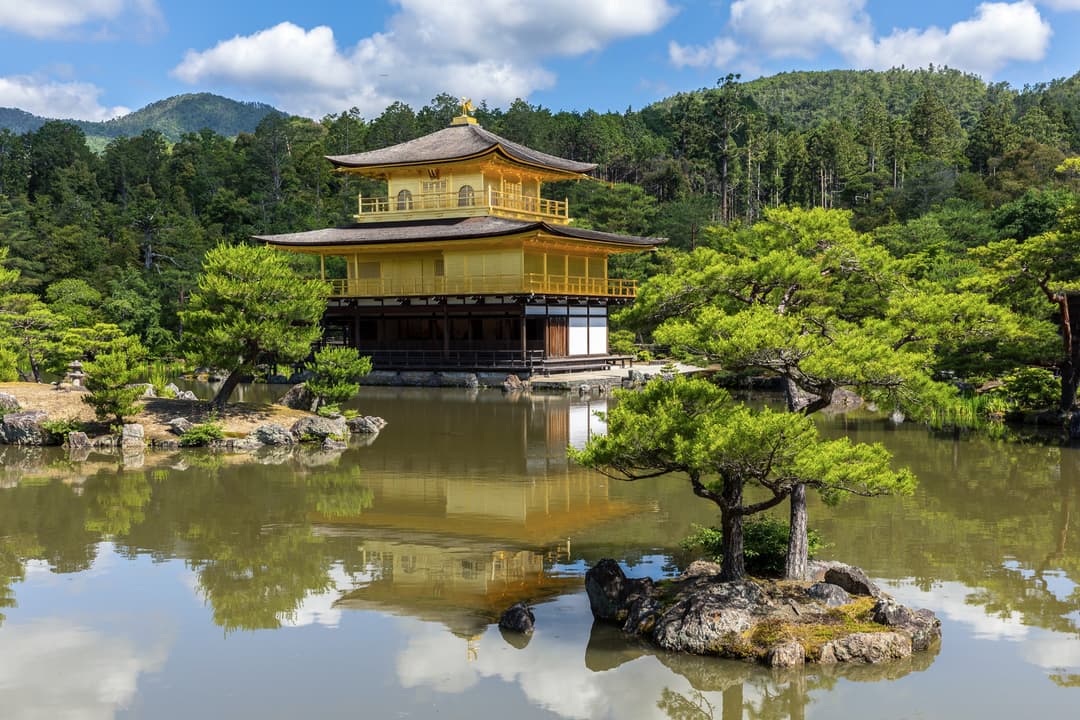 Wide-angle daytime view of Kinkaku-ji reflecting in Mirror Pond.