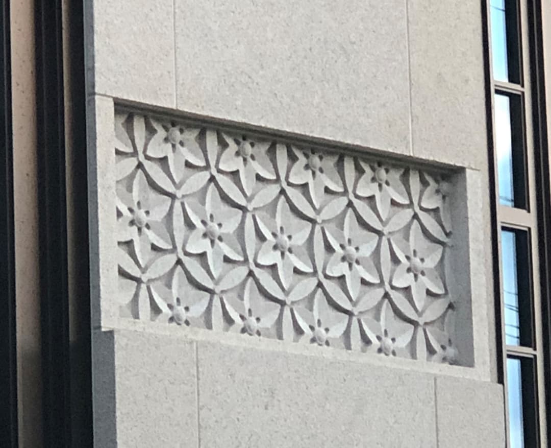 Daytime close-up of Okinawa Japan Temple's carved floral stone panel.
