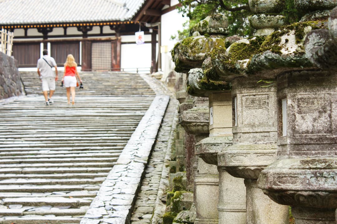 Moss-covered stone lanterns lining a stone staircase at Tōdai-ji.