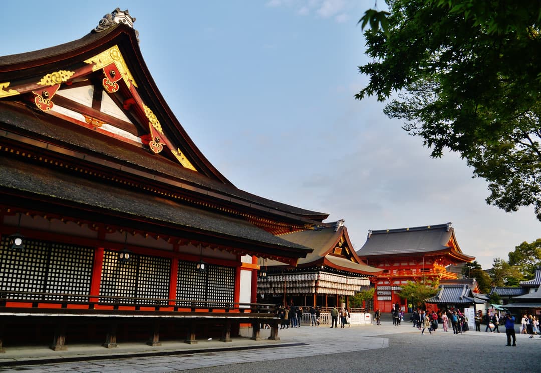 The main hall and lantern-hung dance stage at Yasaka Shrine in late afternoon.