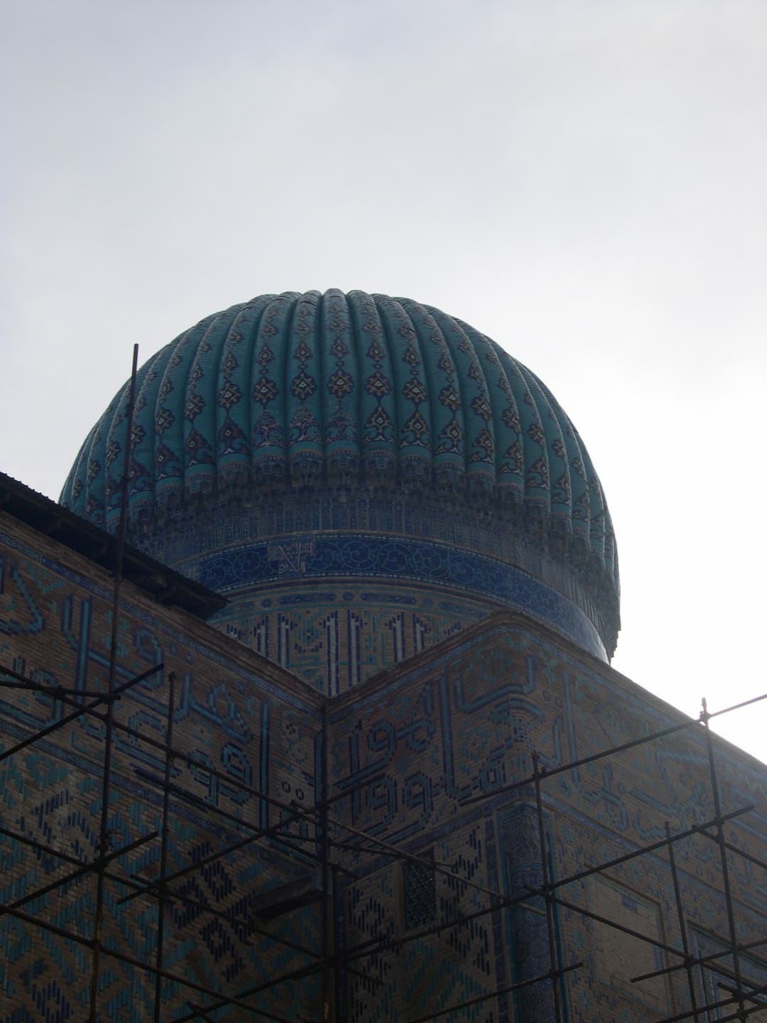 Low-angle view of the ribbed turquoise dome behind scaffolding
