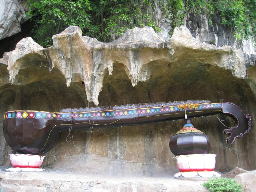 Giant veena sculpture inside a limestone cave alcove