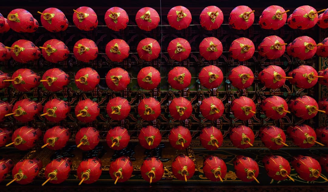 Grid of red Chinese lanterns suspended from a temple ceiling at Kek Lok Si.