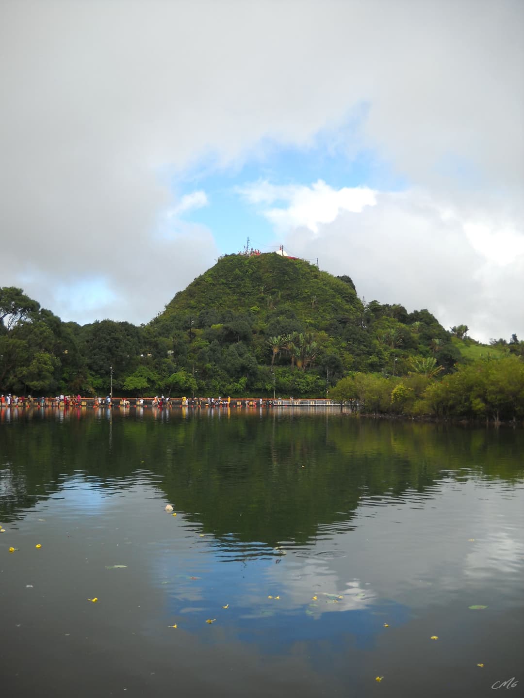 View across the sacred lake toward the forested hill at Ganga Talao.