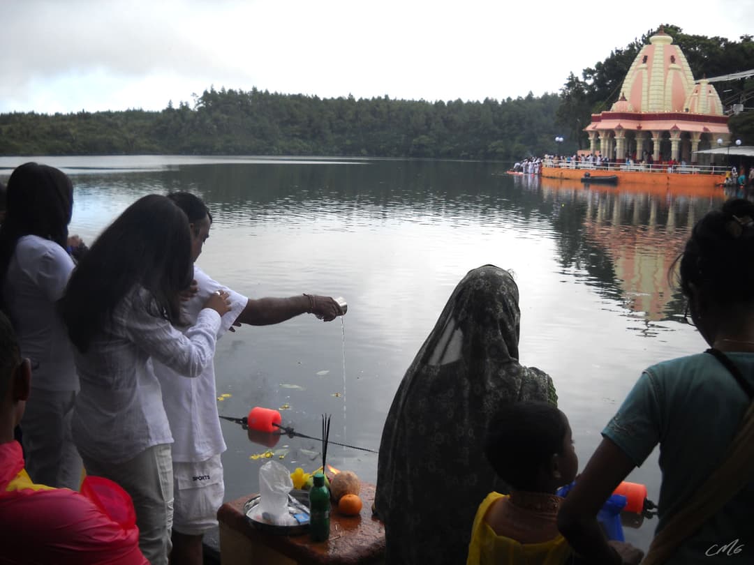 Pilgrims performing rituals at Ganga Talao with the temple in the background