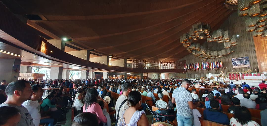 Interior view of the crowded sanctuary in the modern Basilica of Guadalupe.