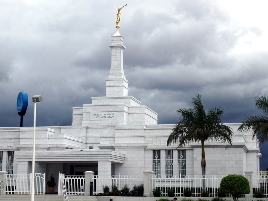 Guadalajara Mexico Temple exterior with Angel Moroni under dark clouds.