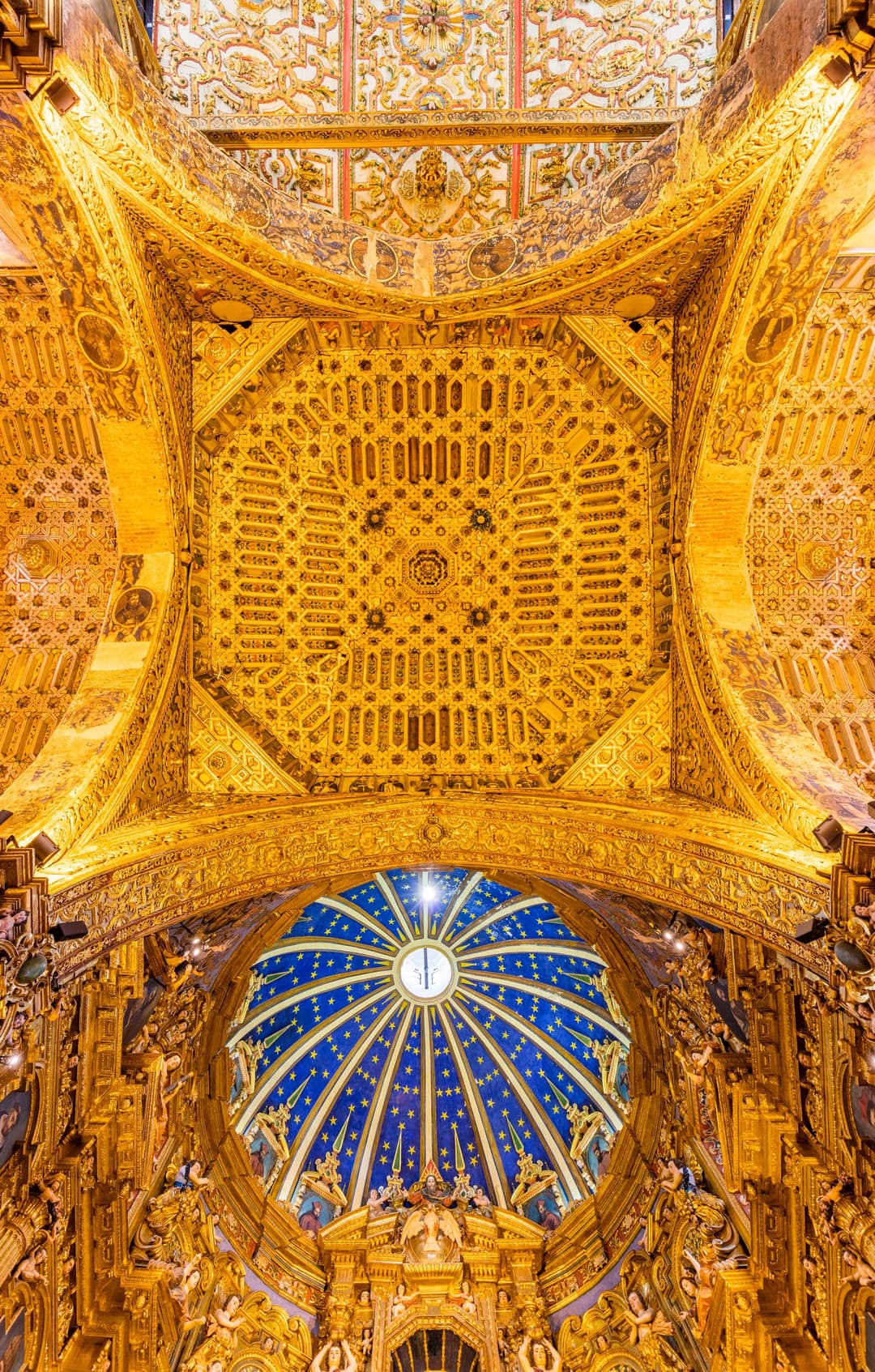 Interior looking up at the ornate gilded ceiling and blue starry dome.